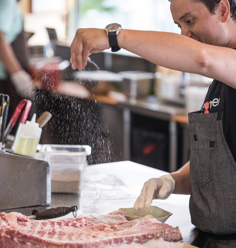 Tender Greens chef preparing meat