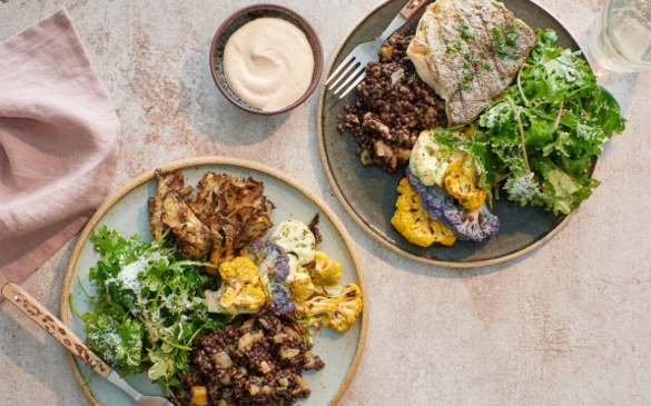 Photo of table with two Tender Greens entrees on plates.